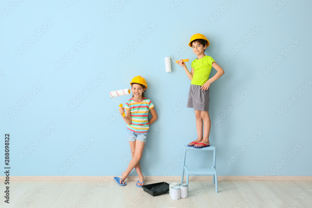 Cute little children painting wall in room