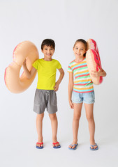 Wall Mural - Cute little children with inflatable rings on light background