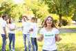 © Pixel-Shot - Female volunteer pointing at her t-shirt outdoors