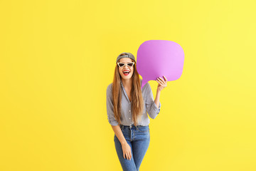 Wall Mural - Happy young woman with speech bubble on color background