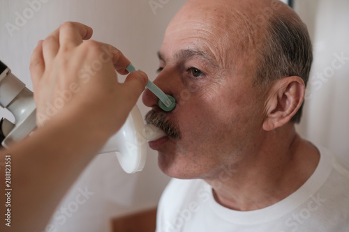Fotografía Senior hispanic man man testing breathing function by spirometry