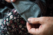 © SilverOwl - Macro elderly woman hands sewing on fabric, needle. Sew pants by old woman hand, seamstress at work with cloth fabric. Grandmother sews. Close up shot. Selective focus