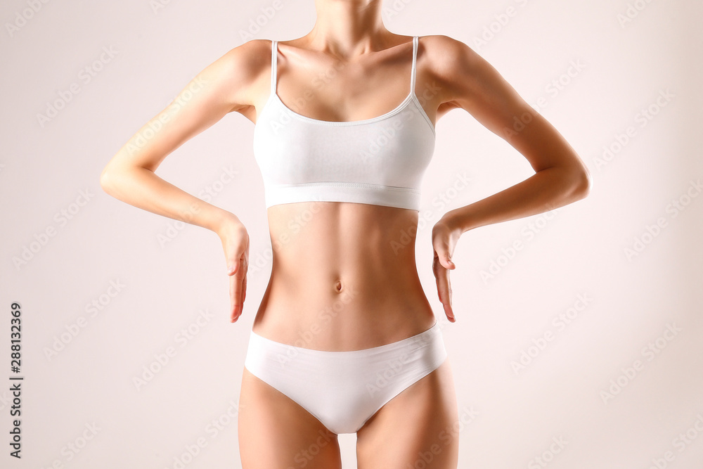 Close up shot of unrecognizable fit woman in lingerie isolated on white background. Torso of slim attractive female with flat belly in white underwear. Copy space for text. - obrazy, fototapety, plakaty 