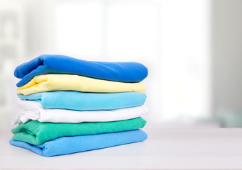 Wall Mural - Stack of cotton colorful folded clothes on table empty space background.