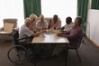© WavebreakMediaMicro - Group of senior people playing chess in living room