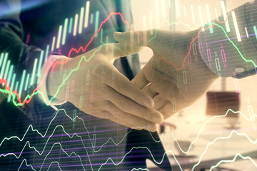 Wall Mural - Multi exposure of financial graph on office background with two businessmen handshake. Concept of success in business