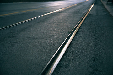 Modern tram rails on the city street. Dark gray asphalt.