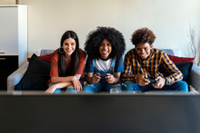 Group Of Happy Young Friends Playing Video Games At Home