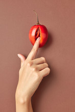 Woman's Finger Touching Tamarillo Exotic Fruit