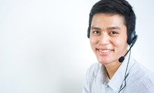 Close Up Call Center Employee Young Asian Man Wear Headset Device And Smiling With Pointing Hand On White Background For Business Telemarketing And Help Desk Design Concept