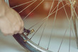 Close-up of a young man prepare to pumping the old bicycle wheel in his home. .