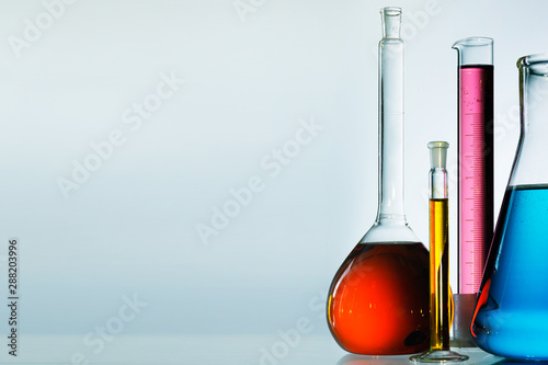 Fotografía Different laboratory glassware with color liquid and with reflection