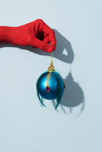 Red Hand With A Blue Christmas Ball