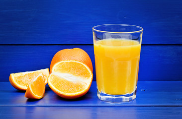 Wall Mural - Orange juice in a glass on wooden table