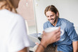 © Westend61 - Laughing young businessman with laptop and businesswoman in office