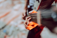 Soft Focus Of Male Musician Clamping Strings On Guitar Fret Board While Playing Music