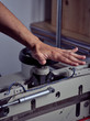 © PHILIPPE DEGROOTE/ADDICTIVE STOCK - Crop hand of competent craftsman rotating handle wheel of binding press machine on blurred background