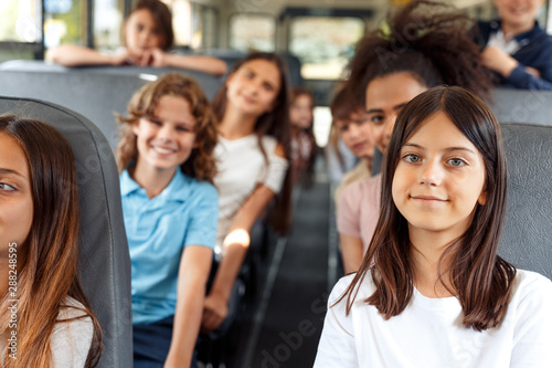 Fotomural Classmates going to school by bus sitting smiling curious close-up blurred backg