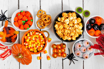 Poster - Halloween candy buffet table scene over a white wood background. Assortment of fun, spooky treats. Top view.