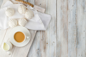Wall Mural - Coffee and white marshmallows on a light wooden tray with copy space