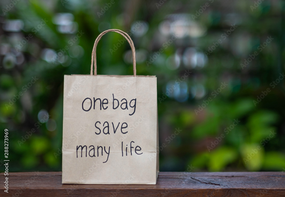 Brown recyclable paper shopping bag Placed on a wooden table, the ...