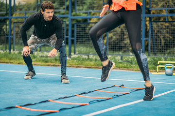 Young Woman Exercise using Agility Ladder, working with Fitness Coach