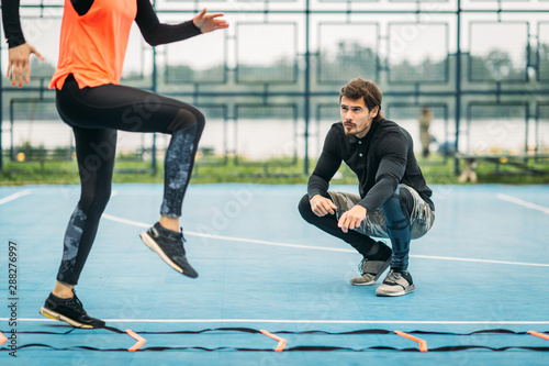 Fotografía Young Woman Exercise using Agility Ladder, working with Fitness Coach