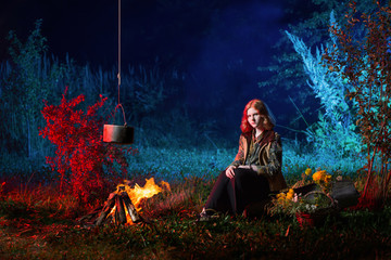 Wall Mural - young witch by  fire in night forest prepares  magic potion