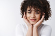 © Cookie Studio - Headshot flirty attractive brunette curly hairstyle smiling happy touching cheeks grinning alluring look camera feel love dreamy sighing watching romantic drama, standing white background