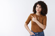 © Cookie Studio - Unsure smart attractive curly-haired girl frowning smirking pointing left look thoughtful pondering important decision making choice standing perplexed unsure cannot remember white background