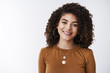 © Cookie Studio - Close-up pleasant curly dark hair female customer support manager smiling broadly ready help express interest happiness grinning white teeth delighted have positive conversation, studio background