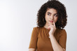 © Cookie Studio - Hmm maybe. Pondering cute curly-haired stylish female thoughtfully look up touch lip thinking make choice deciding what order online shop take decision imaging plan, white background