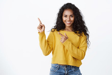 Confident Good-looking African-american Girl With Curly Hairstyle, Look Camera Self-assured And Sassy Smiling, Pointing Upper Left Corner, Introduce Amazing Product, Give Recommendations