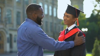 Wall Mural - Afro-american father feeling glad graduating son university mantle, achievement