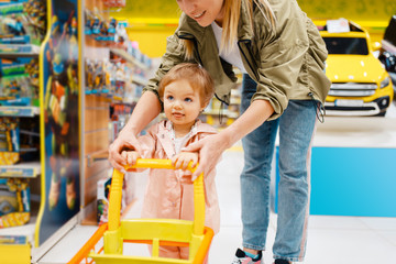 Wall Mural - Happy mother with little daughter in kids store