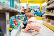 Little boy and girl at the shelf in kids store