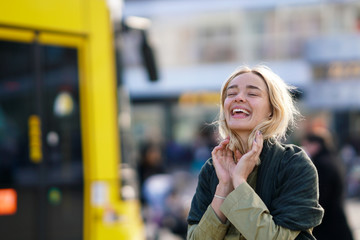 Happy woman in the city with yellow Berlin tramway in the background