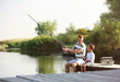 © New Africa - Dad and son fishing together on sunny day