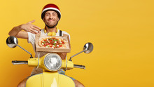 Mmm, How Delicious! Satisfied Man Enjoys Pleasant Smell From Freshly Baked Pizza On Cardboard Box, Has Good Appetite, Transports Delicious Snack For Clients, Poses Over Yellow Scooter In Helmet