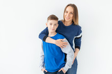 Parenting, Family And Single Parent Concept - A Happy Mother And Teen Son Laughing And Embracing On White Background