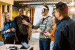 © sofiko14 - Business team of multiracial people working on virtual reality applications and games, young excited man testing VR glasses or goggles standing in the office room with colleagues