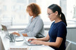 © pressmaster - Two young serious multicultural students sitting by desk in front of laptops