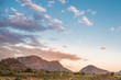 Mountain range and fields in rural Mozambique under a blue sky with pink and purple clouds from the setting sun. Nampula Province, Mozambique, Africa