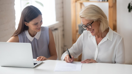 Canvas Print - Smiling senior woman sign business contract in office