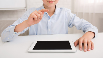 Poster - Schoolboy with tablet pc studying in classroom