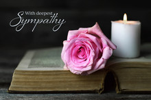 Sympathy Card With Burning Candle And Rose On Open Book
