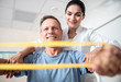 © Yakobchuk Olena - Happy male patient using rubber band for fitness