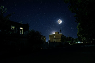 Wall Mural - full moon over quite village at night. beautiful night landscape of old town street with lights. rus