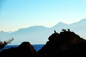 Poster - Mediterranean seascape image of people sailing on tour boat over high mountains with sunny sky in Antalya, Turkey