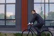 © ty - Handsome young businessman riding on his bicycle in the city. Ecologic transport concept.